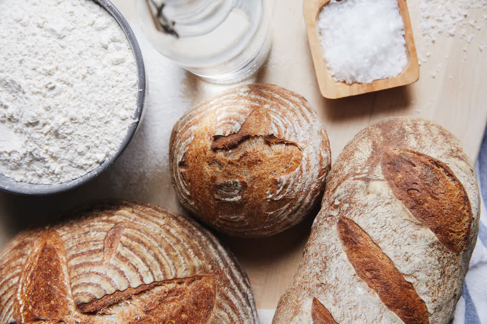 Fresh sourdough loaves with flour and salt