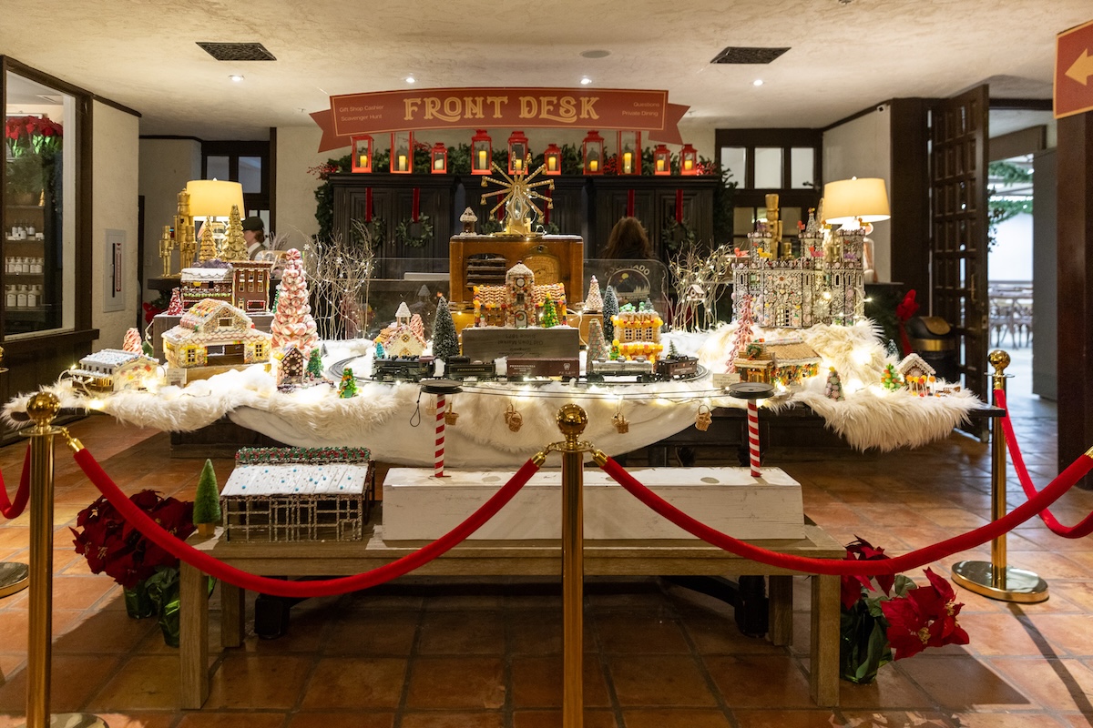 The Front Desk decorated for Christmas with a gingerbread village and toy train